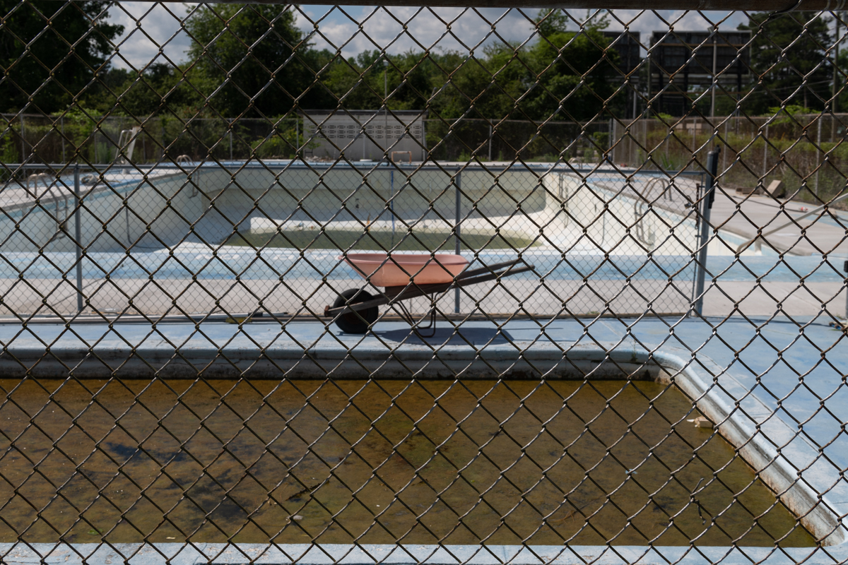 a wheelbarrow in front of an empty pool