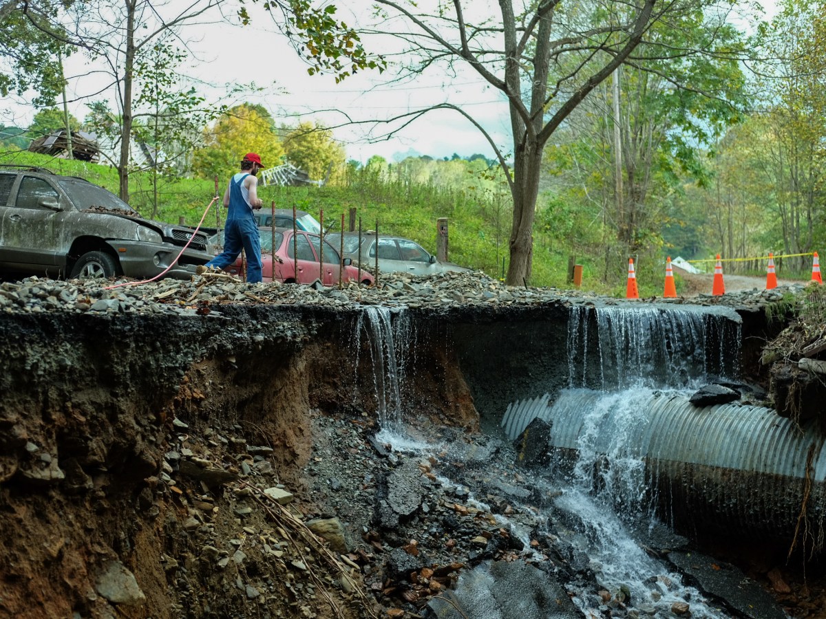 A man walks beside a destroyed road