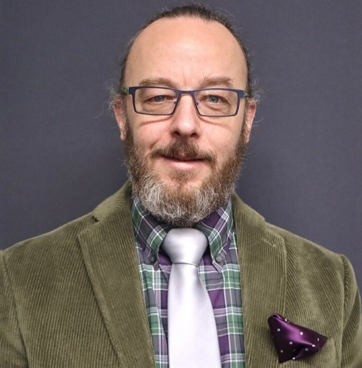 Wade Maki wears glasses and a tie